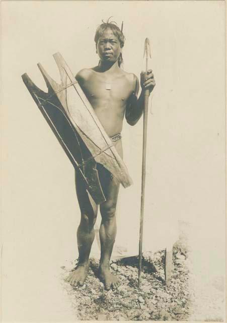 Igorot warrior posed with lance, shield, and head axe