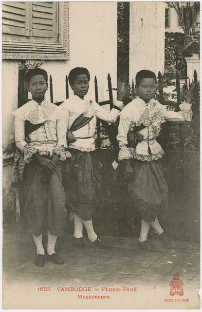 Three people in front of fence