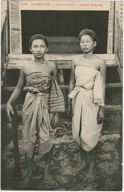 Two young women in front of window