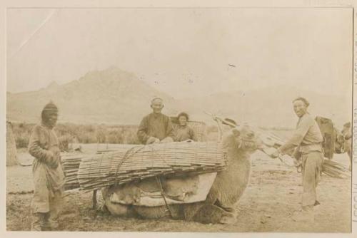 Men, and camel laden with possible skin racks