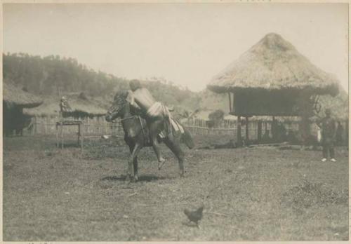 Igorot man vaulting onto the back of a horse