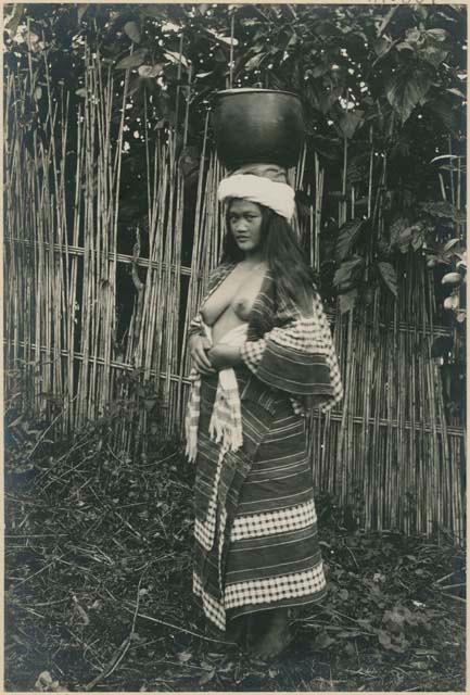 Igorot woman with iron pot filled with water balanced on her head