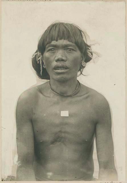 Bontoc Igorot man wearing deer horn ear ornaments and piece of coral in hair