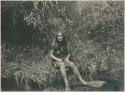 Beguet Igorot woman sitting on the bank of a stream