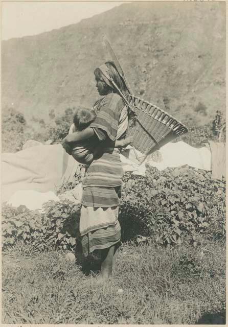 Igorot woman carrying child and basket