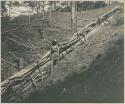 Igorot woman next to fence enclosing a clearing