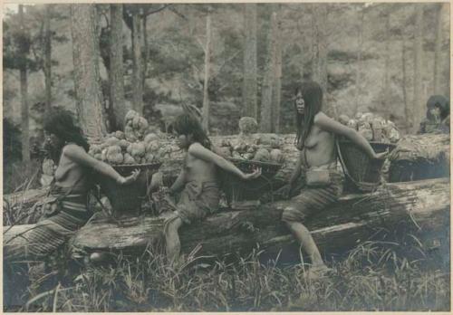 Igorot women and girl resting from carrying camotes