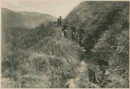 Igorot women and girls carrying clay