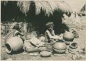 Igorot woman shaping rim of a pot