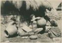 Igorot woman shaping rim of a pot