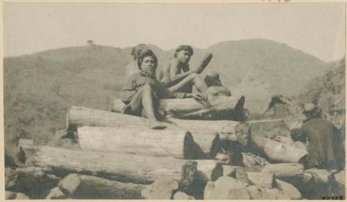 Group of Bontoc Igorot men perched on a pile of firewood