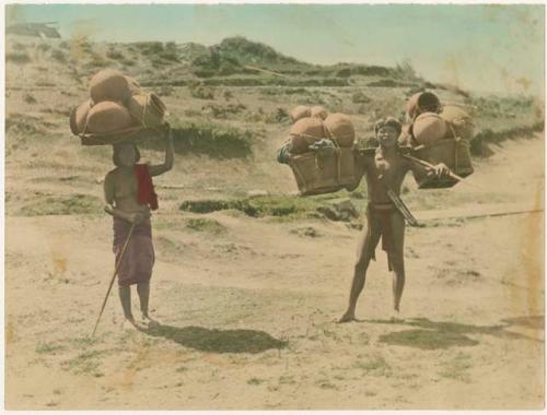 Woman and man carrying bundles of ceramic pots