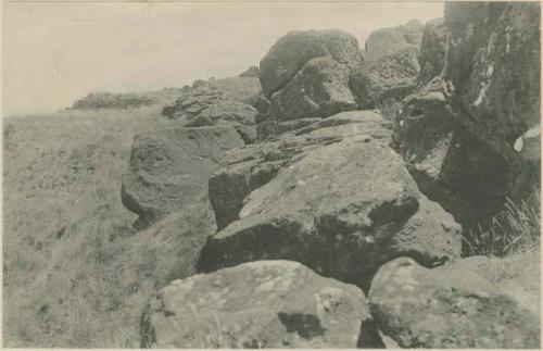 Sculptured rocks, with stone house in background
