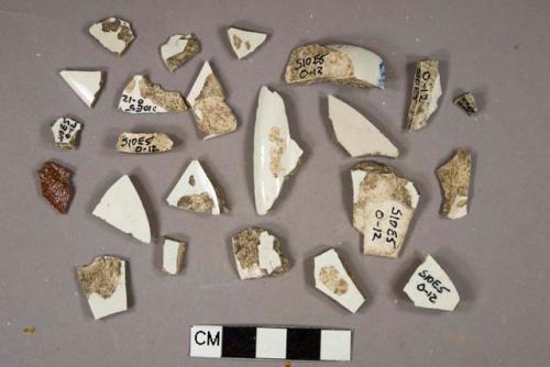 White lead glazed vessel fragments, 2 rim fragments, 20 body fragments, white or light buff paste, 4 blue on white transferprinted decoration, 1 red salt glazed redware vessel body fragment