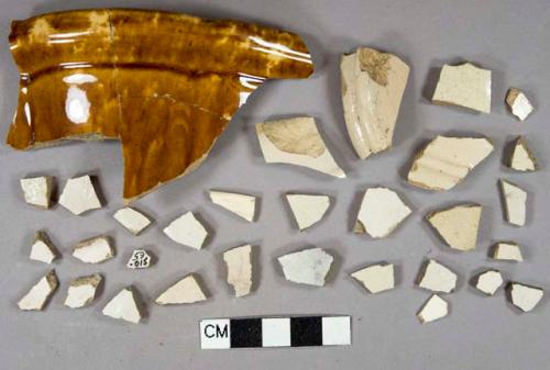 27 undecorated white saltglazed stoneware body fragments, 1 base fragment, buff and gray paste, 5 white lead glazed vessel body fragments, buff paste, 1 frim fragment with molded decoration, 1 crossmended brown leadglazed rockinghamware vessel rim fragment, molded decoration on body