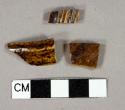 Brown lead glazed earthenware vessel rim and body fragments, buff paste, 1 fragment with molded lines