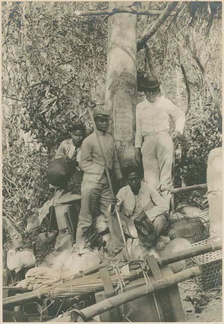 Group of Ilocano men gathering around tree