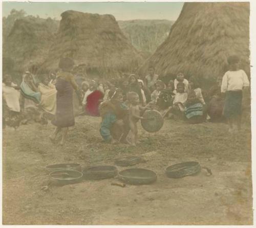 Igorot. Baby and woman in village surrounded by group of children and women