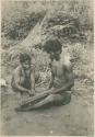Ilongot woman and man playing musical instrument made from bamboo