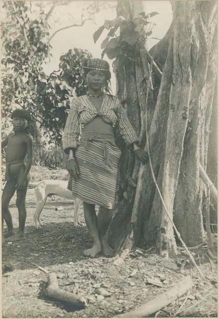 Kalinga woman standing at the base of tree house support