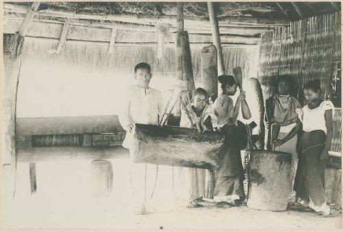 People extracting oil using a wooden press called a 'japitan'