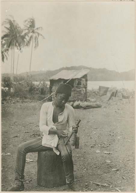 Boy striking fire with bamboo tool