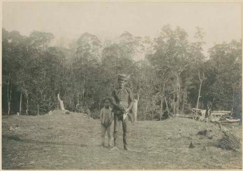 Man and his grandson standing in a clearing