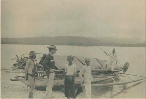 Dr. Barrows with Samal "Moros" and their boat, and a fish-spear