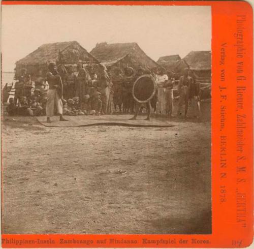 Two Moro men with shields, group of Moros, houses