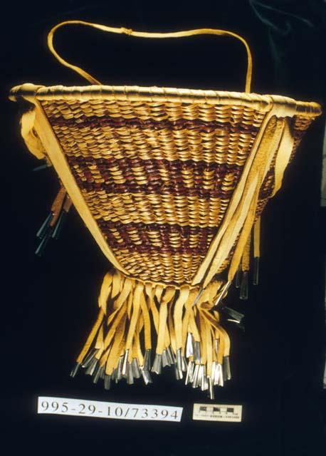 Twined burden basket with leather fringe and tin tinkers