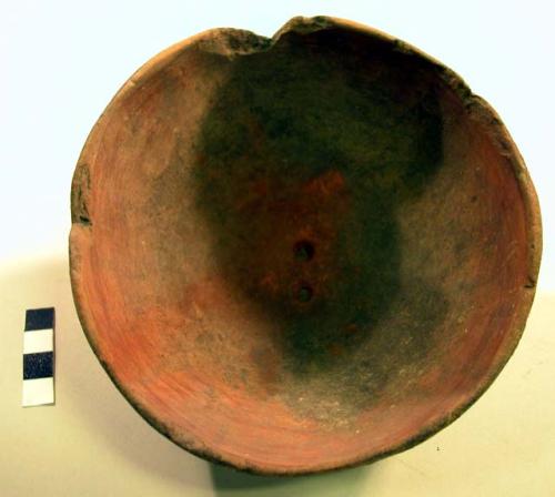 Ceramic bowl, complete, burnt exterior, chipped rim, red ocre found inside