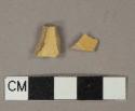 Undecorated yellow lead glazed earthenware vessel body fragment, buff paste