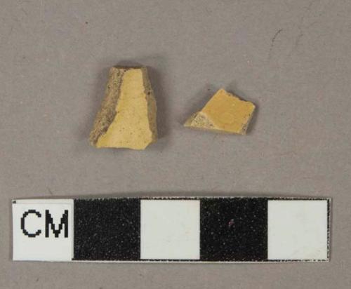 Undecorated yellow lead glazed earthenware vessel body fragment, buff paste