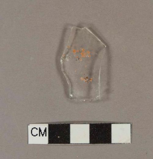 Colorless bottle glass fragment with fragments of orange paint or label