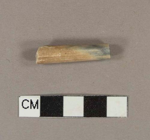 Unsmoked, undecorated pipe stem fragment, possibly tobacco-stained; 5/64" bore diameter