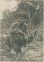 Man squatting on a log