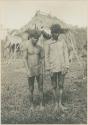 Two Mangyan men standing in front of hut