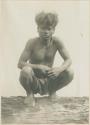 Mangyan man squatting on a log