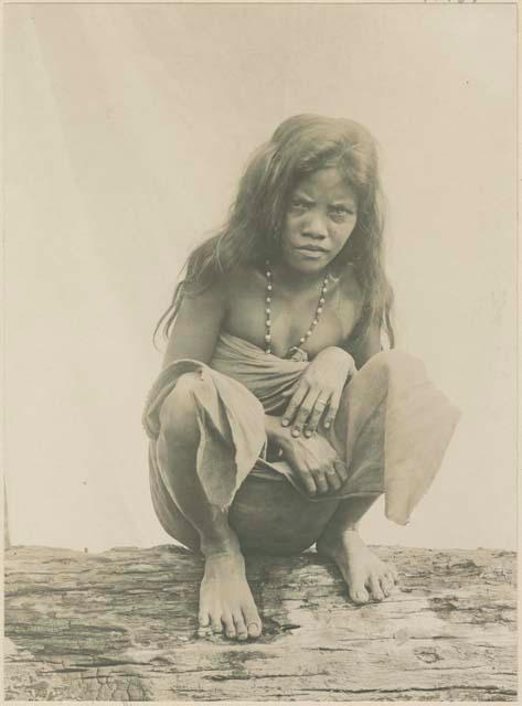 Mangyan woman squatting on a log