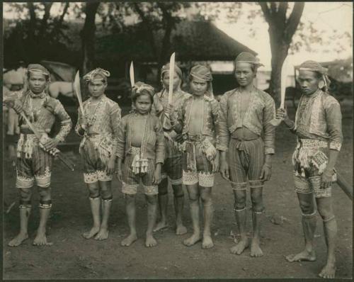 Young men with swords, beaded garments