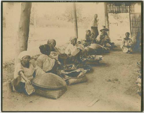 Women squatting, woven baskets