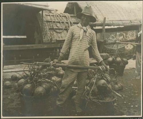 Man with two large baskets of produce