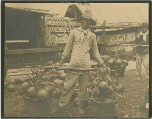 Man with two large baskets of produce