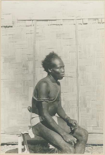 Batak man sitting, smoking native made cigar