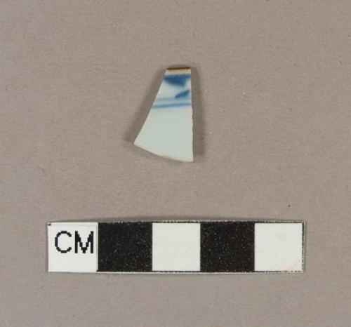 Blue hand painted porcelain rim sherd with brown glaze on top of rim