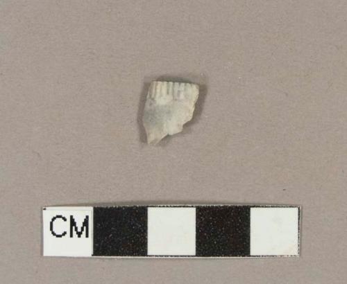 Smoked pipe bowl fragment with rouletted rim and possible other molded decoration