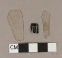 2 colorless plastic sheet fragments, 1 black and brown curved plastic fragment