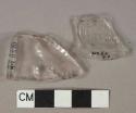 Colorless glass vessel body fragments, 1 fragment with molded lettering "[...]USK[...]", 1 fragment molded decoration