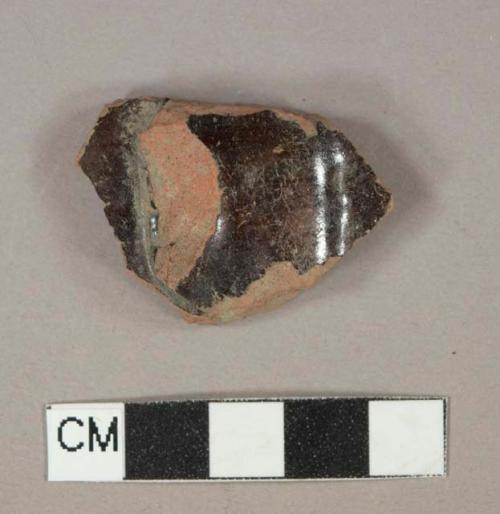 Dark brown slip glazed redware vessel body fragment