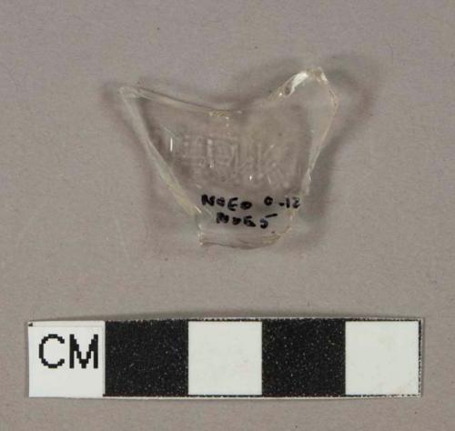 Colorless glass vessel body fragment, molded lettering "[...]IRK[...]"